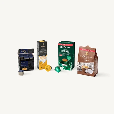 Qbo Espresso Kapseln in blauer Box, Cafissimo Caffe Crema Kapseln in schwarz-gelber Box, Eduscho Lungo Cremoso Kapseln in grüner Box und Caffè Crema Pads in braunem Beutel, jeweils mit einzelnen Kapseln/Pads daneben.