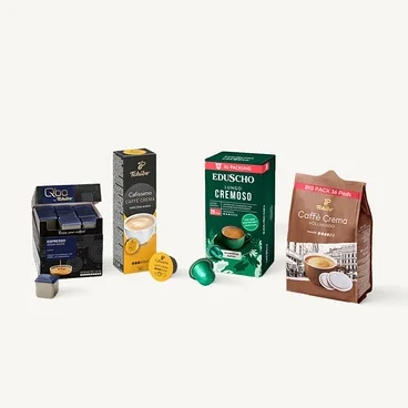 Qbo Espresso Kapseln in blauer Box, Cafissimo Caffe Crema Kapseln in schwarz-gelber Box, Eduscho Lungo Cremoso Kapseln in grüner Box und Caffè Crema Pads in braunem Beutel, jeweils mit einzelnen Kapseln/Pads daneben.