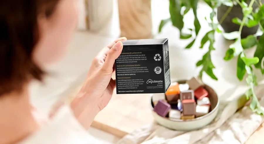 Frau hält eine Packung Qbo Espresso APANECA ANA.
