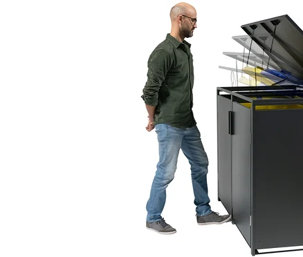 Ein Mann mit Brille öffnet einen schwarzen Mülltonnenschrank mit dem Fuß.