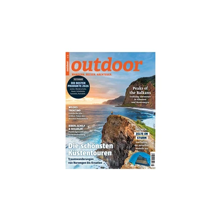Magazincover „outdoor“: Eine Person steht auf einer Klippe mit Blick auf das Meer bei Sonnenuntergang, Berge im Hintergrund. Ein blaues Zelt ist unten rechts zu sehen. Titel: „Die schönsten Küstentouren“, „Peaks of the Balkans“.