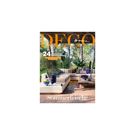 Magazincover von DECO Home mit einer Outdoor-Lounge: L-förmiges Sofa mit Kissen, Couchtisch und Pflanzen. Text: „24 Extraseiten Outdoor-Möbel“, „Farbe und Tapeten“, „Sommerfrische“.
