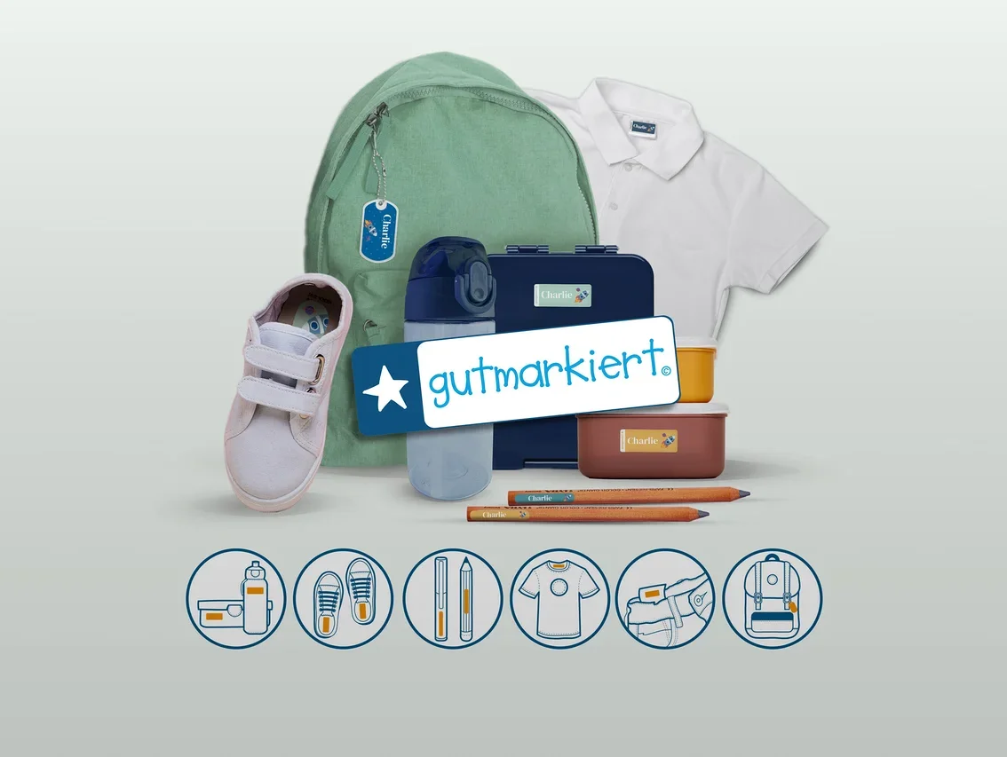 Verschiedene Schulartikel wie ein grüner Rucksack, ein weißer Schuh, eine blaue Trinkflasche, zwei Brotdosen, zwei Bleistifte und ein weißes Poloshirt sind mit personalisierten „Charlie“-Etiketten versehen. Ein „gutmarkiert.“-Logo ist mittig platziert, darunter zeigen Symbole Anwendungsbeispiele für Etiketten.