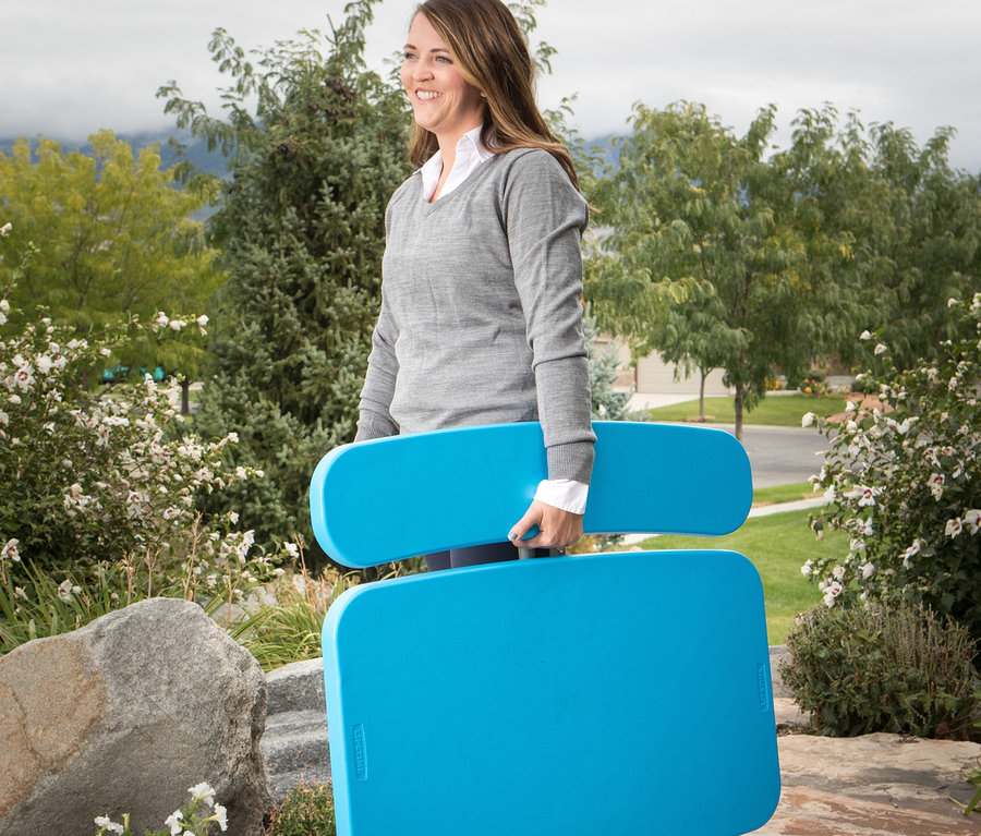 Frau trägt blauen LIFETIME Kinder-Picknicktisch »80094G« im Freien.