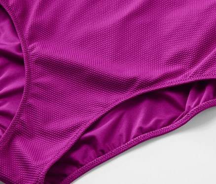 Detailaufnahme eines violetten Badeanzugs mit strukturierter Oberfläche.