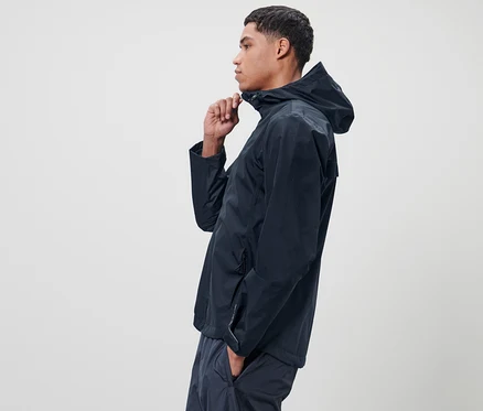 Mann schliesst blaue Unisex-Regenjacke.