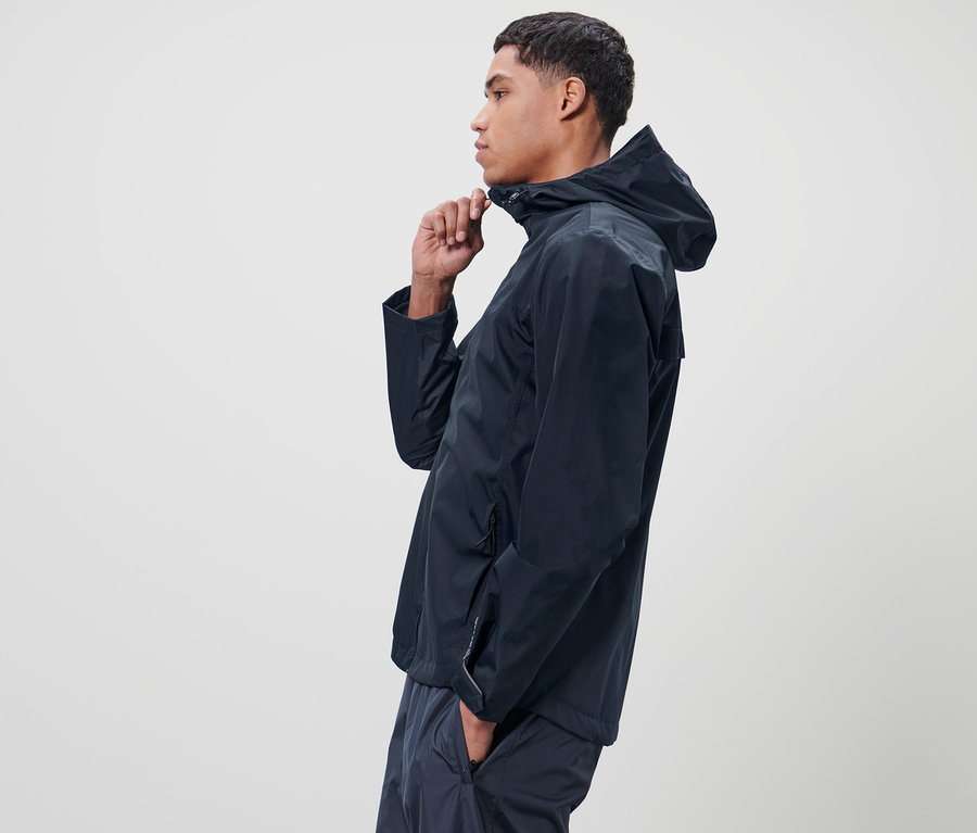 Mann schliesst blaue Unisex-Regenjacke.