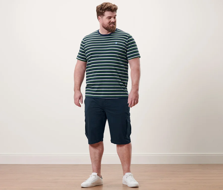 Mann steht auf Holzboden und trägt navy Cargo-Shorts und 2 T-Shirts mit Rundhalsausschnitt.
