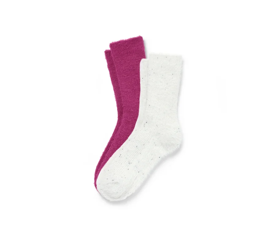 Zwei Paar flauschige Kuschelsocken mit Effektgarn, ein Paar lila, ein Paar weiß.