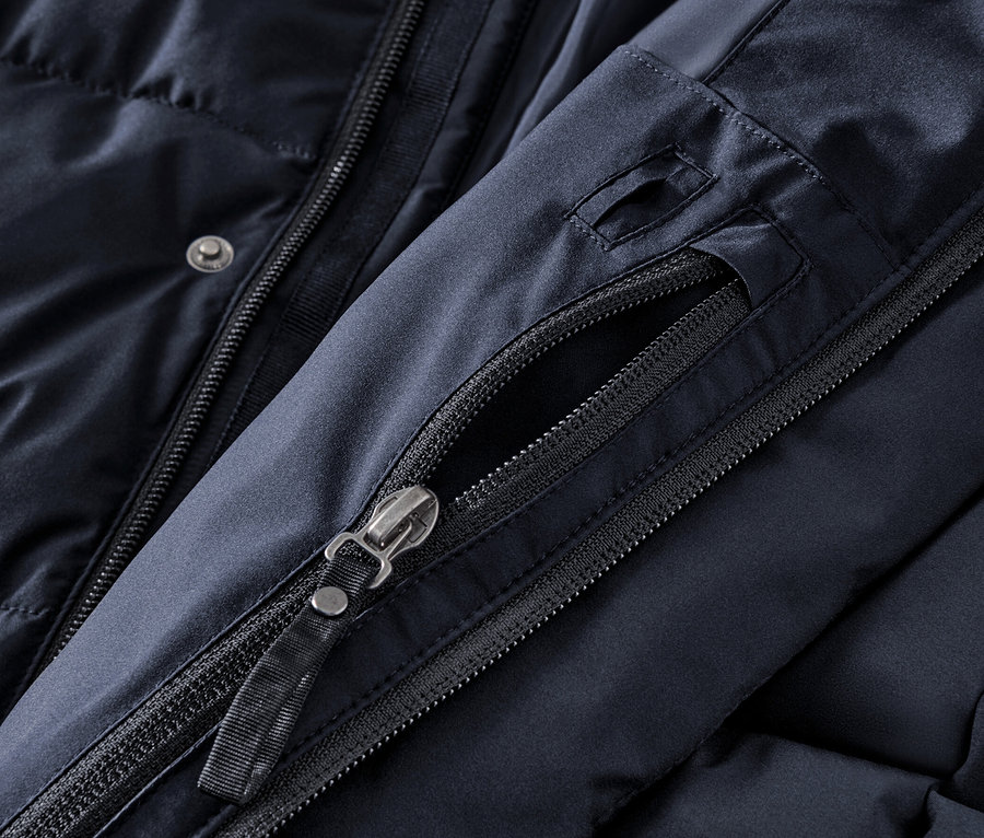 Detailansicht eines marineblauen Stepp-Parkas mit Kapuze, Reißverschluss und Knöpfen.