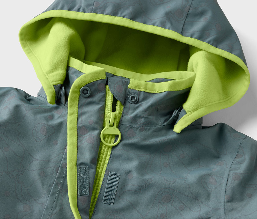 Detailansicht einer Kinder-Thermo-Regenjacke mit reflektierenden Elementen, Kapuze mit neonfarbenem Futter.