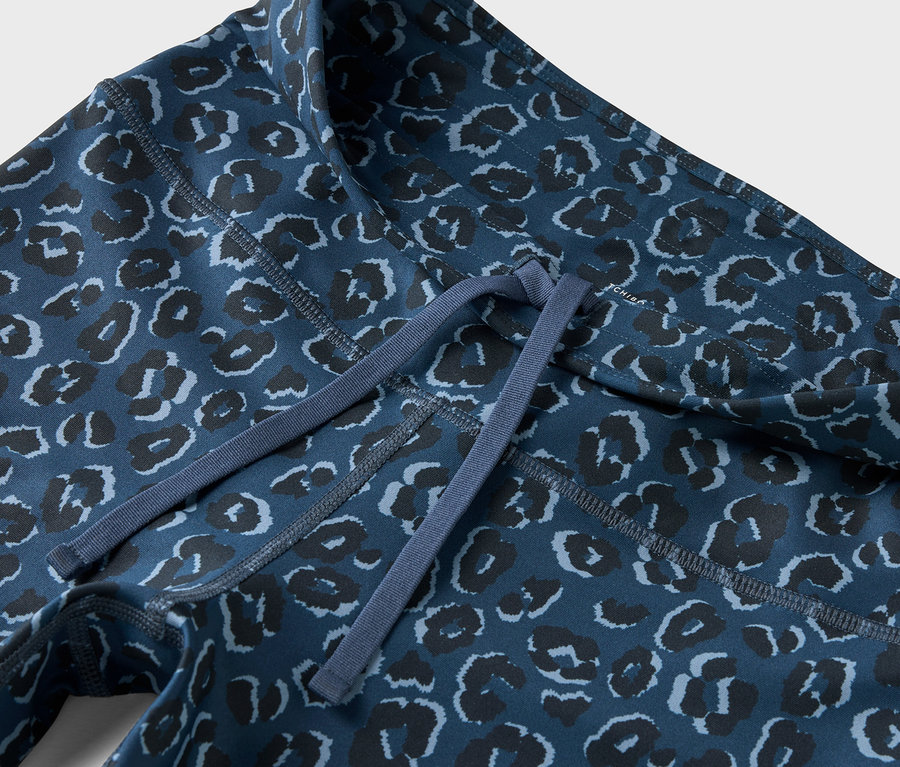 Detailaufnahme von blauen Leggings mit Tiermuster und Kordelzug in der Taille.