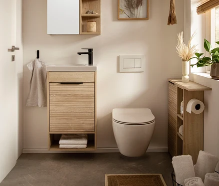 Badezimmer mit Waschbecken, Spiegelschrank und Toilette. Inklusive »Mads« Nischenschrank.