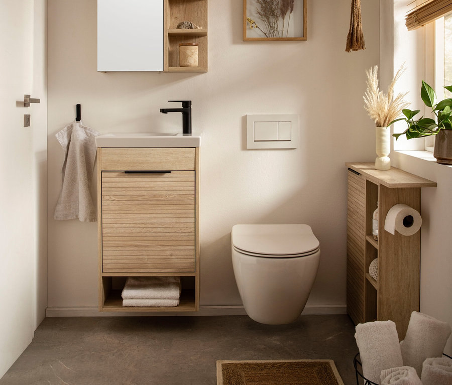 Badezimmer mit Waschbecken, Spiegelschrank und Toilette. Inklusive »Mads« Nischenschrank.