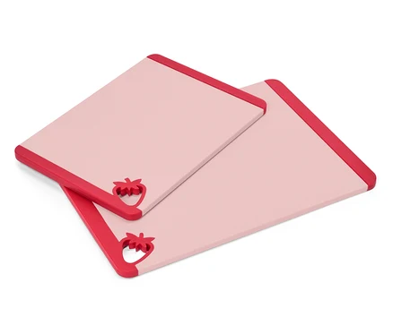 Zwei rechteckige, rosa Schneidebretter mit roten Erdbeer-Akzenten an einer Ecke liegen übereinander.