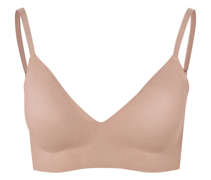 Nahaufnahme eines hautfarbenen BHs mit dünnen Trägern vor weißem Hintergrund.