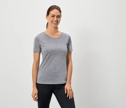Frau trägt ein graues T-Shirt und schwarze Leggings.