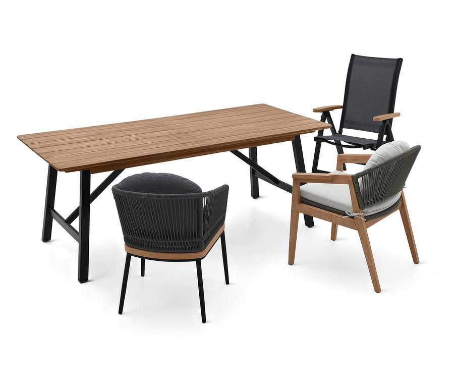 Holzesstisch mit schwarzen Metallbeinen und drei Stühlen mit grauen Kissen.