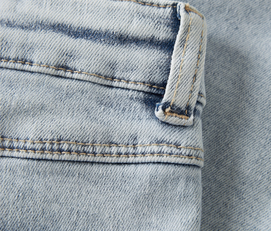 Detailaufnahme von hellblauen Jeans mit rosa Herzstickerei.