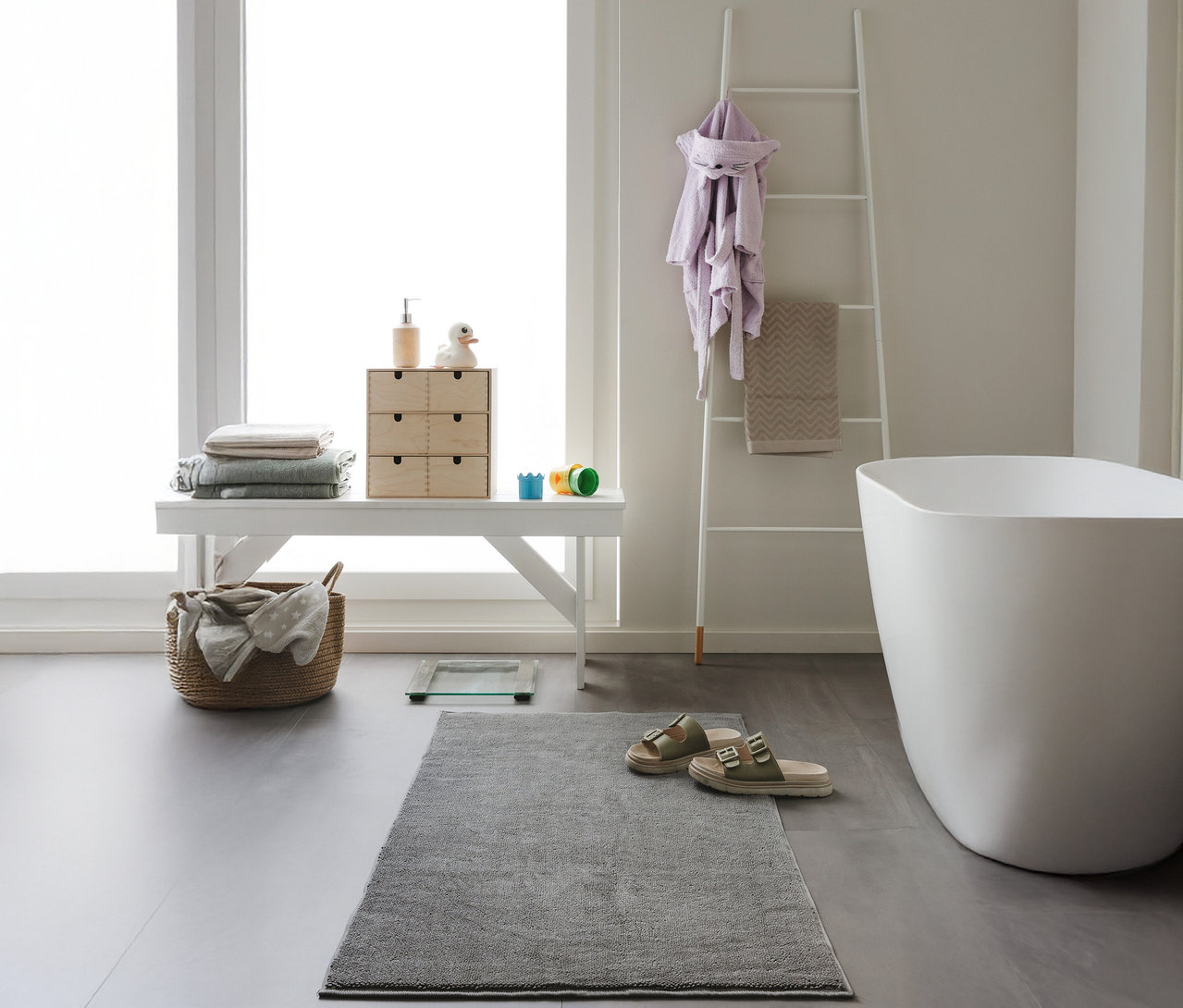 Ein Badezimmer mit einer anthrazitfarbenen benuta Badematte »Ole« (50 x 80 cm) vor einer Badewanne.