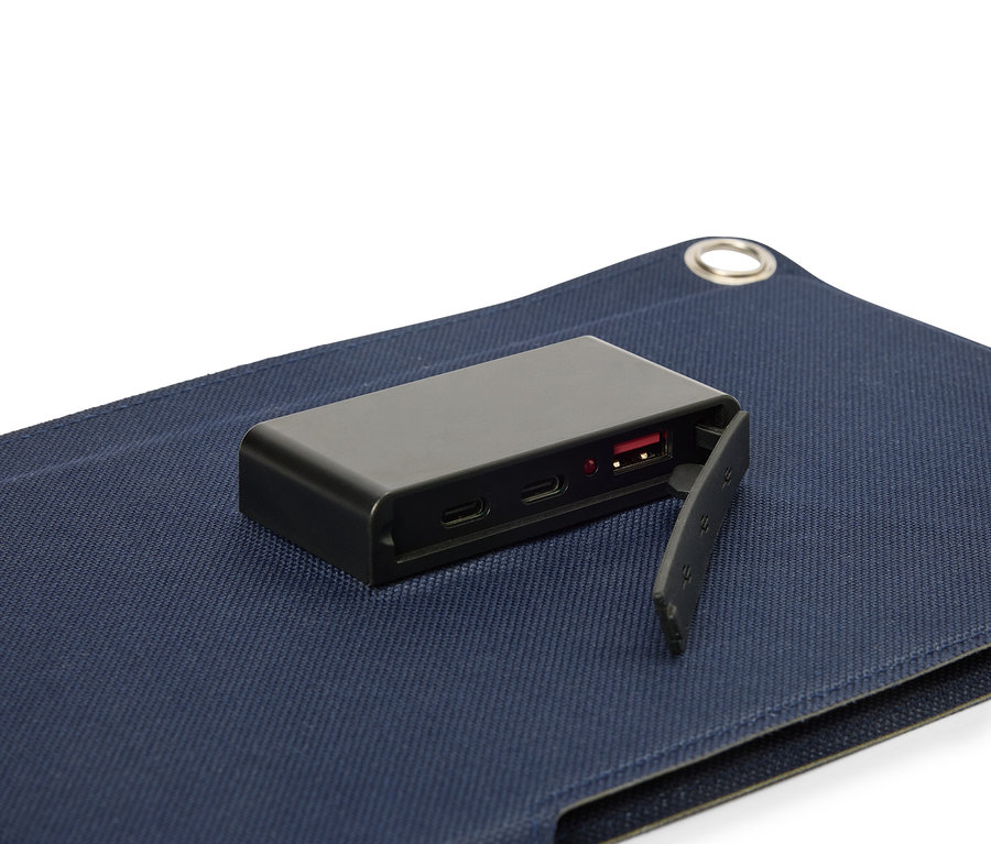 Schwarzer Akku liegt auf einer blauen Stoffoberfläche, wobei der USB-Anschluss sichtbar ist.