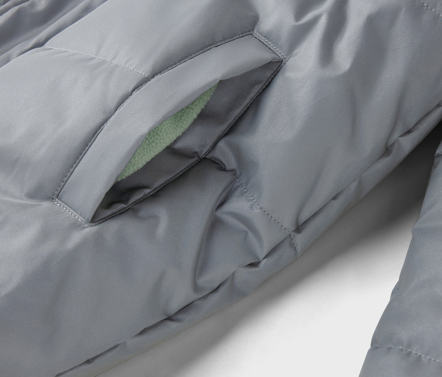 Nahaufnahme einer grauen, gesteppten Jacke mit einer Tasche, deren Futter hellgrün ist.