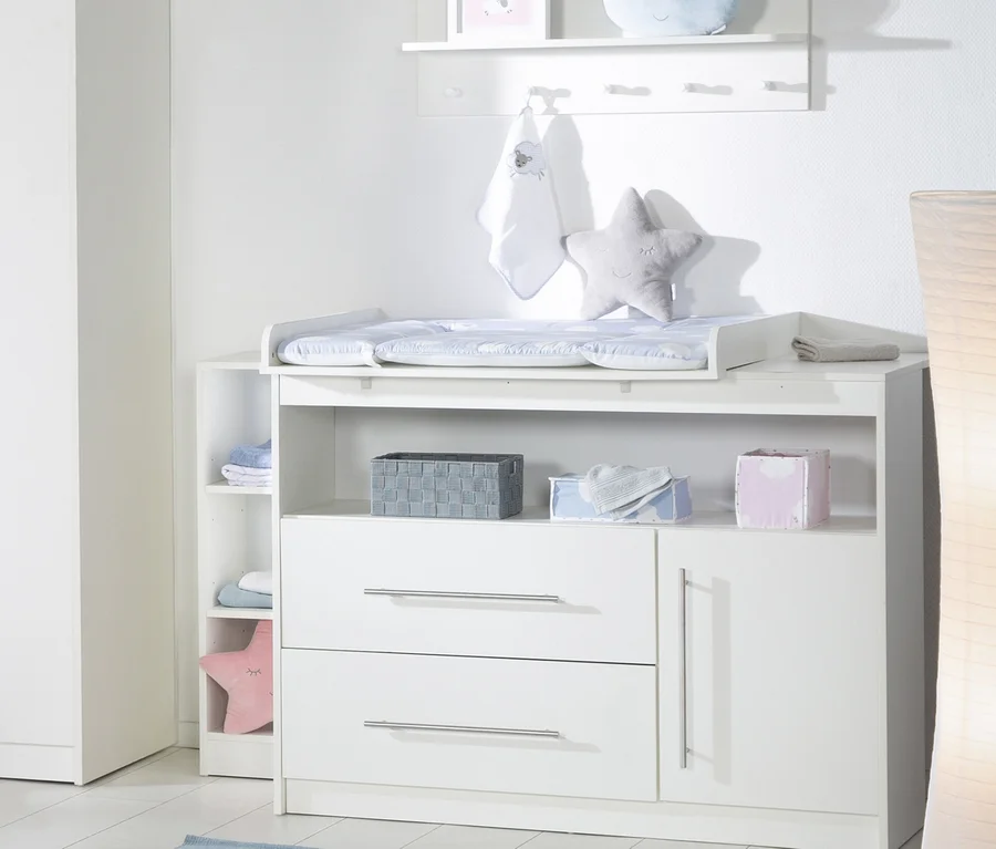 Detailansicht eines weißen Kinderzimmers mit Wickelkommode und Stauraum.