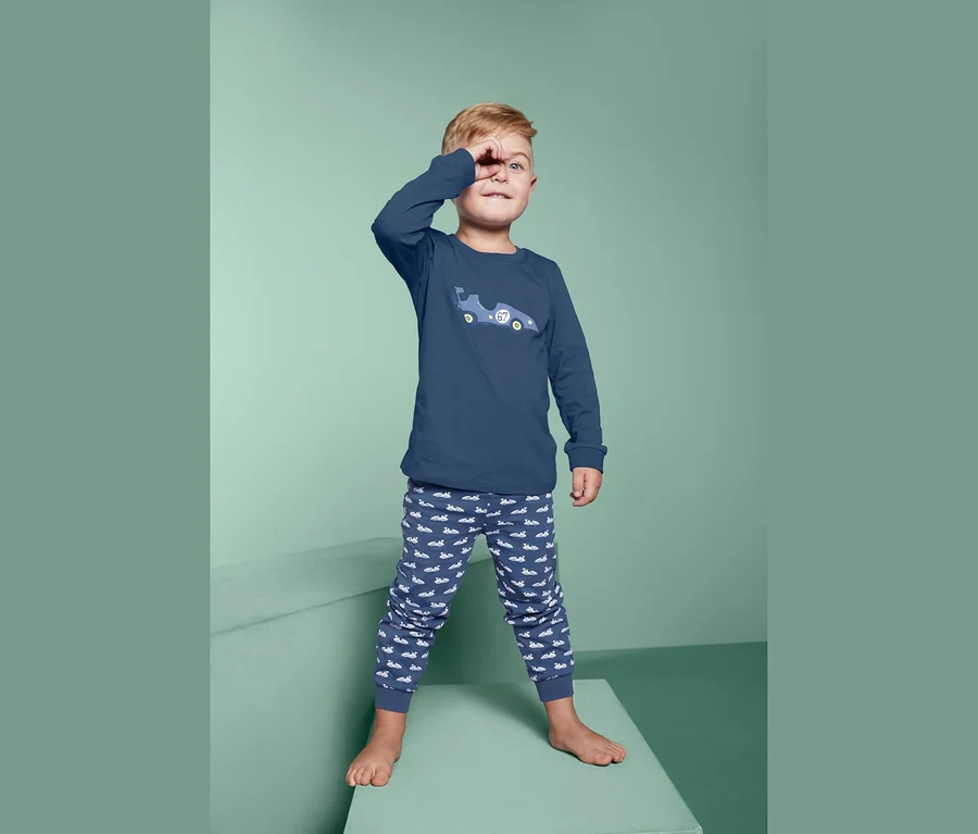 Junge winkt in seinem Pyjama.