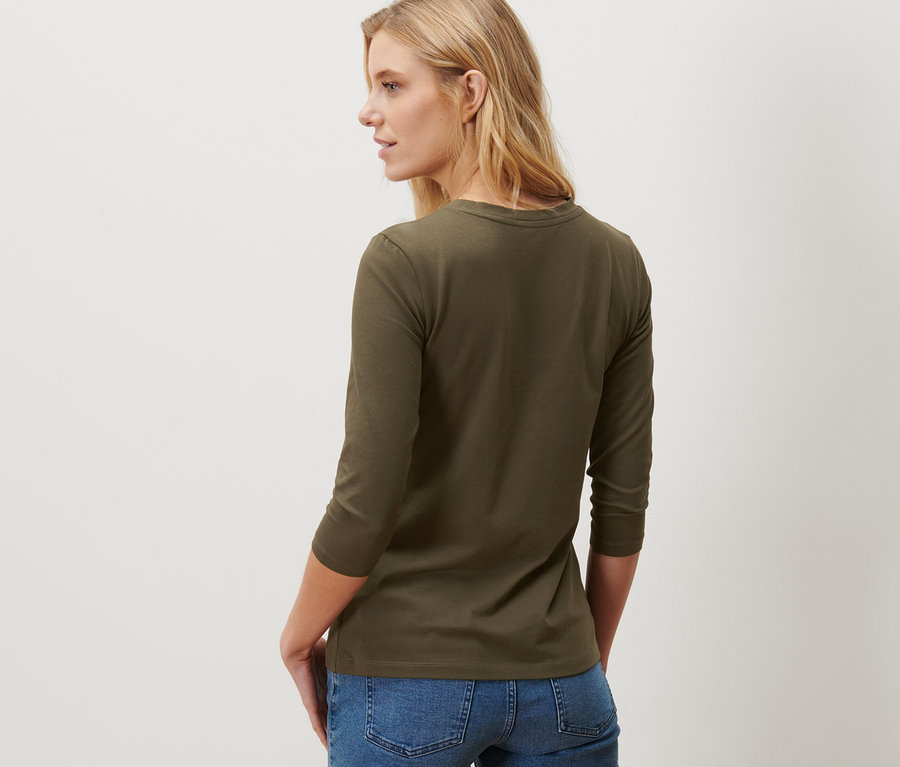 Frau trägt ein Shirt mit 3/4-Arm in Khaki.
