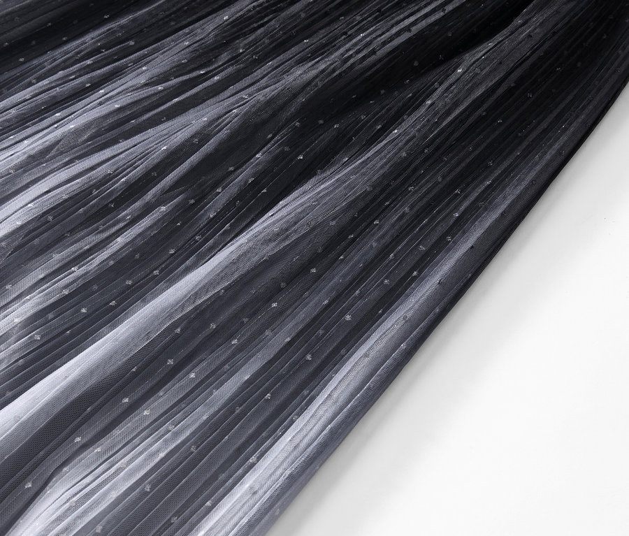 Detailansicht eines plissierten Tüllrocks mit Farbverlauf.