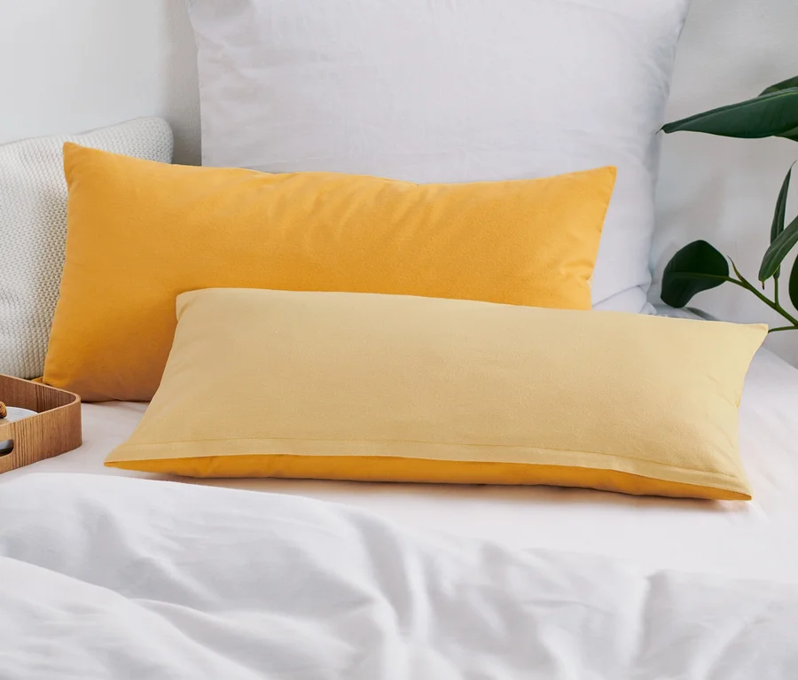 Auf einem Bett liegen zwei gelbe Biber-Kopfkissenbezüge.