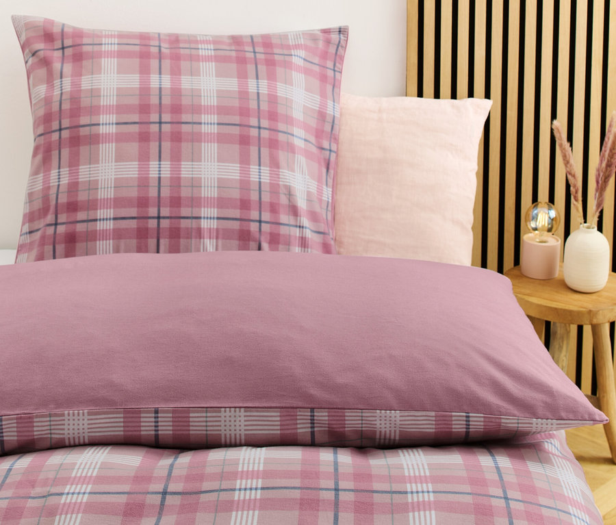 Nahaufnahme von Biber-Bettwäsche in Normalgröße mit einem Karomuster in Rosa- und Weißtönen.