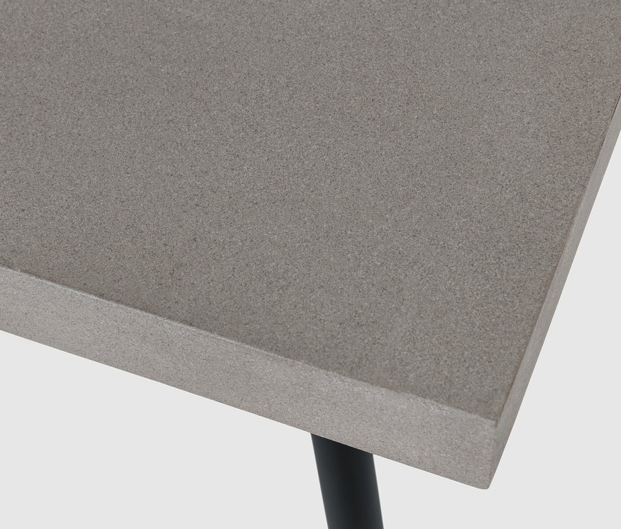 Detailansicht eines Couchtischs mit Polyzement-Tischplatte und schwarzen Beinen.