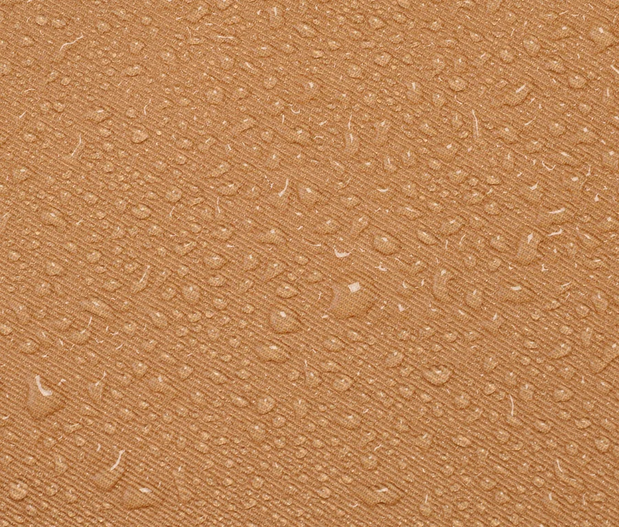 Nahaufnahme eines grünen Outdoor-Kissens mit Wassertropfen.