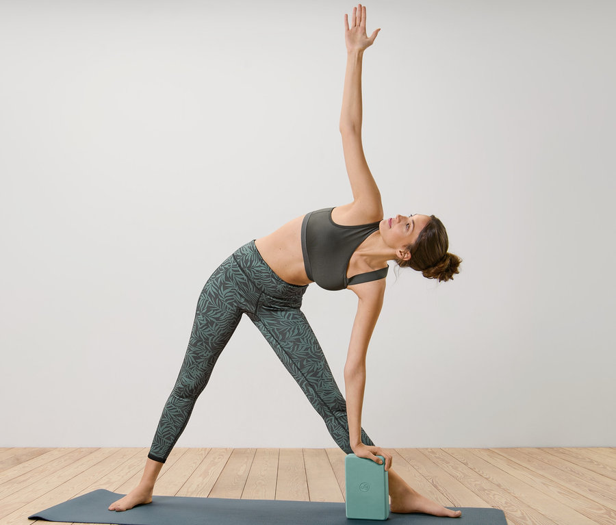 Frau macht Yoga mit einem Yoga-Block.