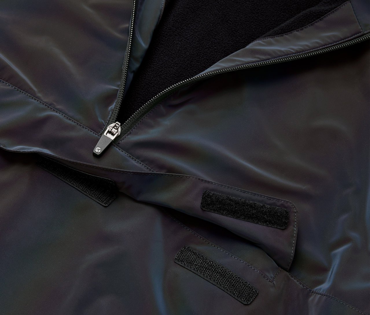 Detailaufnahme einer Windjacke Rainbow Reflective mit geöffnetem Reißverschluss.