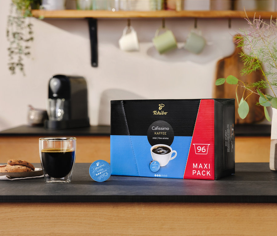 Ein Glas Kaffee und Kekse neben einer Packung Cafissimo Kaffee kräftig - 30 Kapseln.