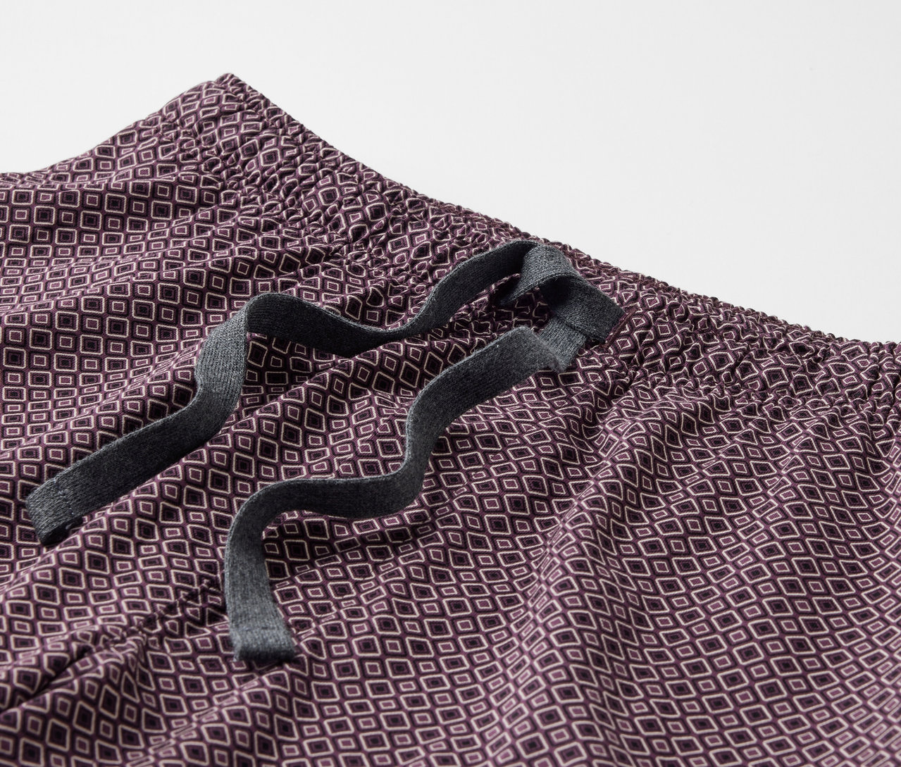Detailansicht eines Shorty-Pyjama-Sets mit geometrischem Muster und Kordelzug in der Taille.