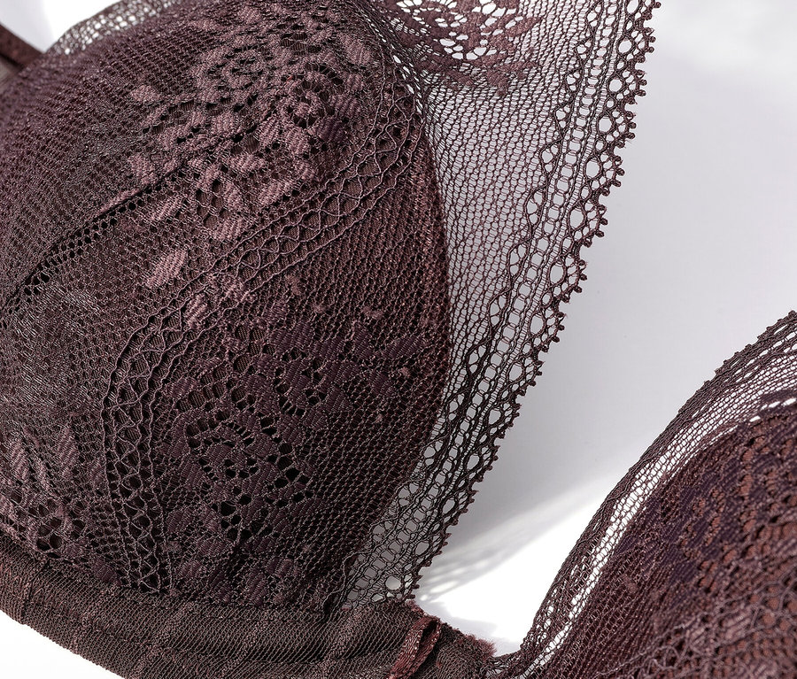 Nahaufnahme eines dunkelvioletten Spitzen-BHs auf weißem Hintergrund.