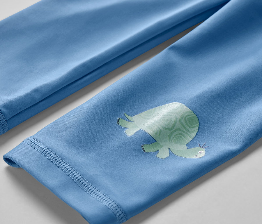 Detailaufnahme von Kinder-Badeleggings mit UV-Schutzfaktor 80, mit Schildkrötenmuster.