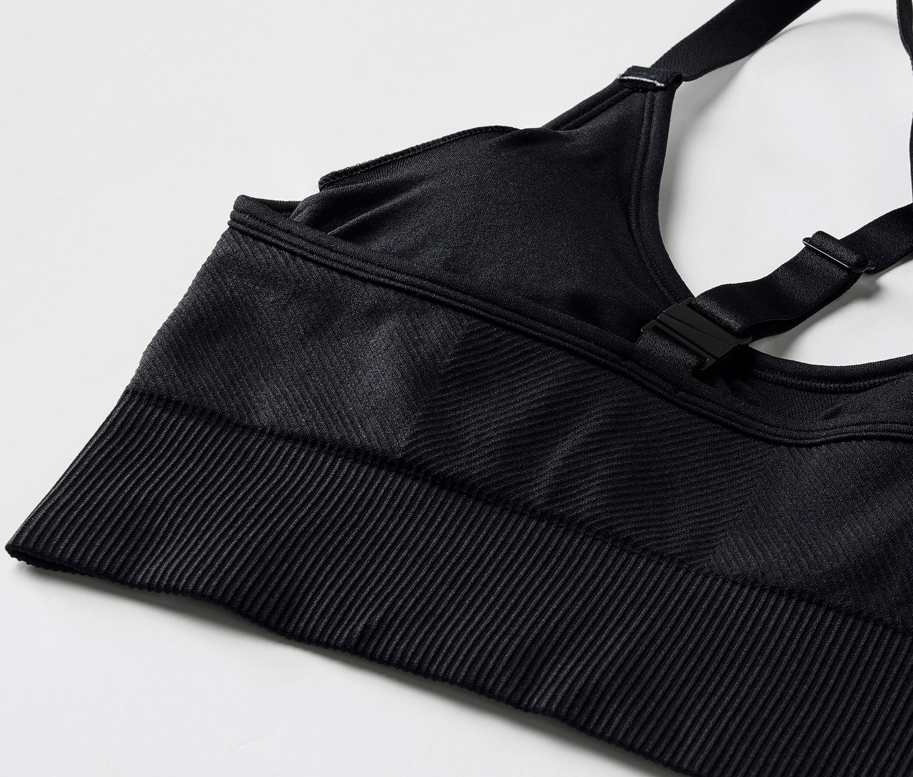Detailaufnahme eines schwarzen Sport-BHs mit verstellbaren Trägern und geripptem Saum.
