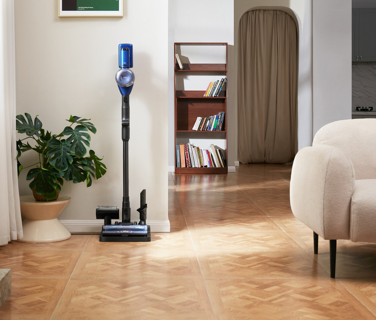 Tineco Akku-Staubsauger »Pure One S50 Pro« steht auf einem Holzboden neben einer Zimmerpflanze.