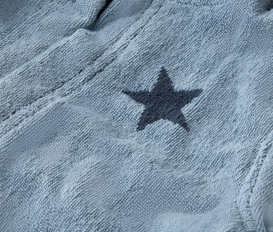 Nahaufnahme eines hellblauen Bademantels mit dunkelblauen Sternen.