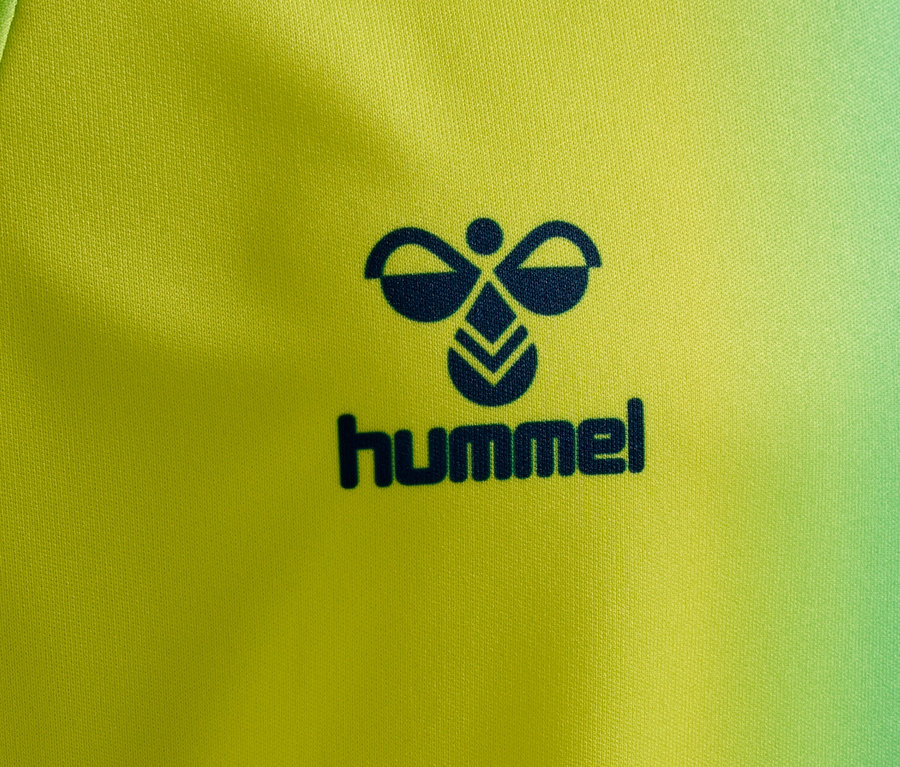 Nahaufnahme eines gelb-grünen Stoffes mit einem dunkelblauen Hummel-Logo.