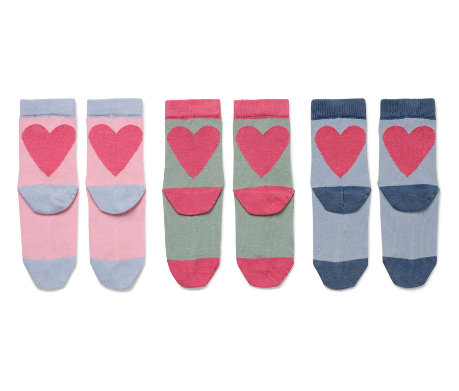Drei Paare Socken mit rosafarbenen Herzen auf rosa, grün und blau.