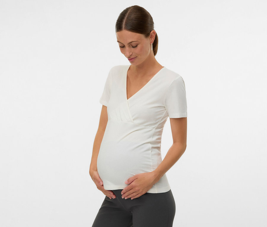 Schwangere Frau hält ihren Bauch und trägt ein MAMALICIOUS 2er Pack T-Shirt »MLKERRIE TESS« in Weiß.