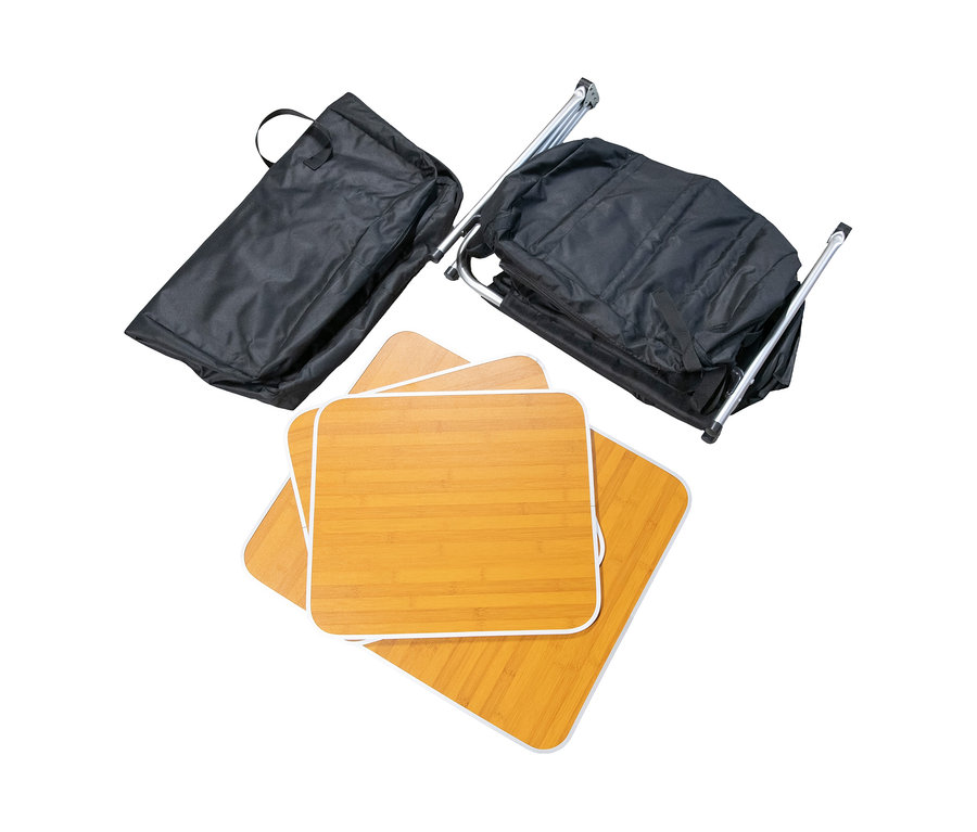 Faltbarer Campingtisch mit Stauraum, bestehend aus drei quadratischen Tischplatten in Holzoptik, zwei schwarzen Tragetaschen und einem zusammengeklappten Metallgestell.