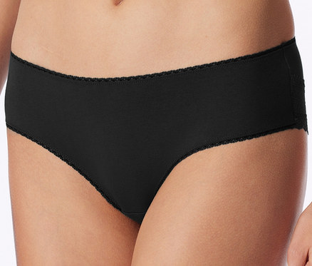 Nahaufnahme einer Person, die einen schwarzen Slip mit zarter Wellenkante an Bund und Beinöffnungen sowie Spitzendetail an der Hüfte trägt.