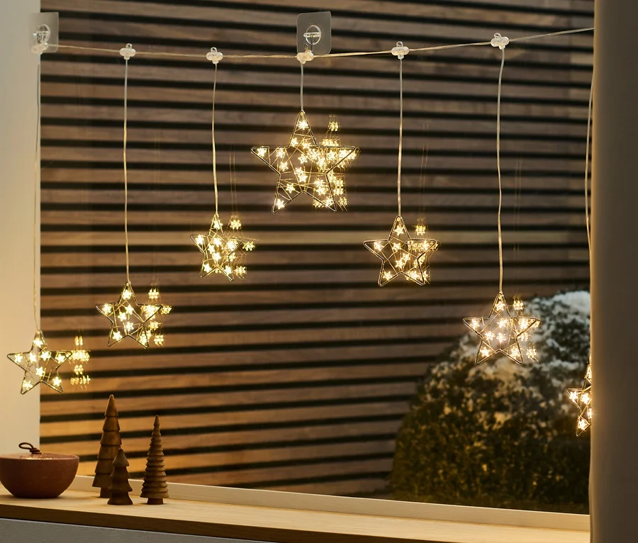 LED-Lichtvorhang in Sternform hängt am Fenster.