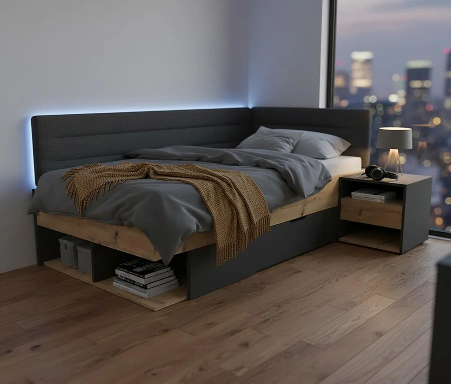 Graues Bett mit Überwurf und Kopfkissen neben einem Roba Nachttisch »Marvin« mit Lampe und Kopfhörern.